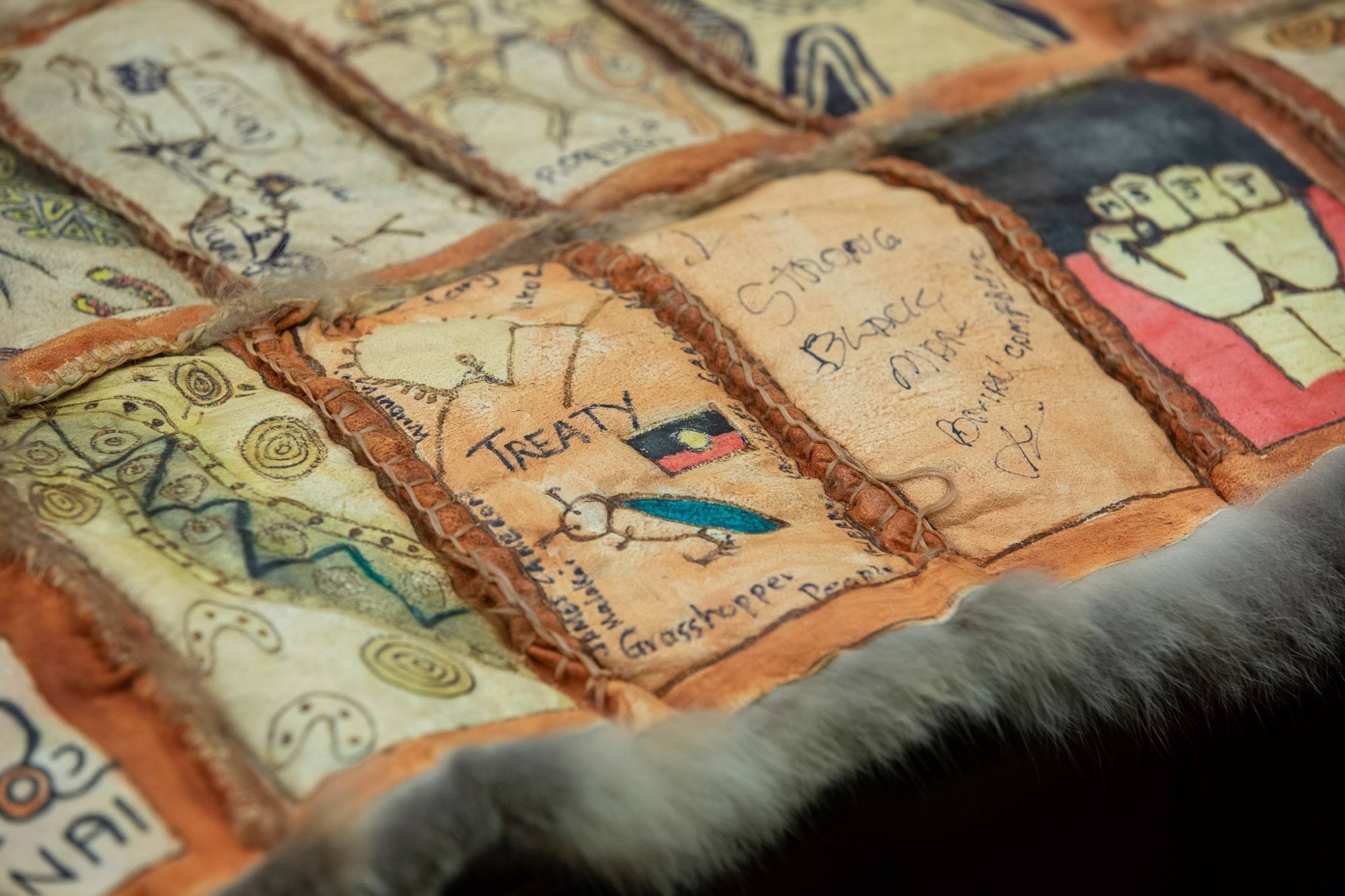 Possum skin cloak with artwork on panels about Treaty.